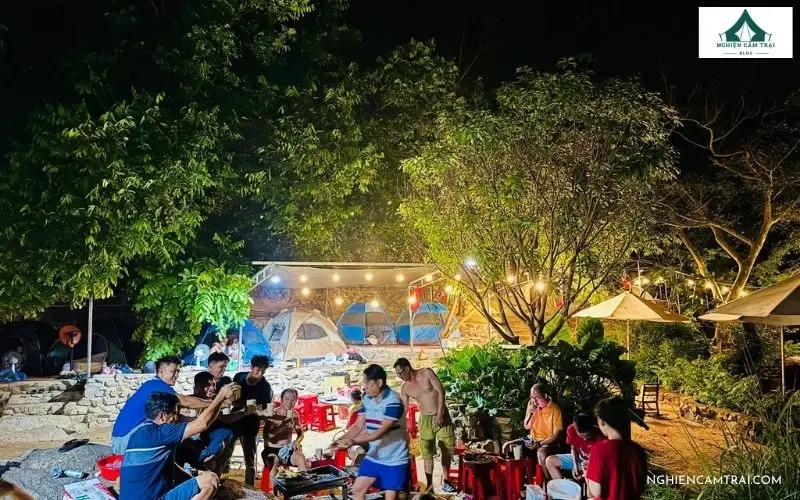 Khu vực cắm trại và lều glamping sáng rực ánh đèn về đêm tại Suối Mơ Dốc Tình Glamping & Retreat Khánh Hòa